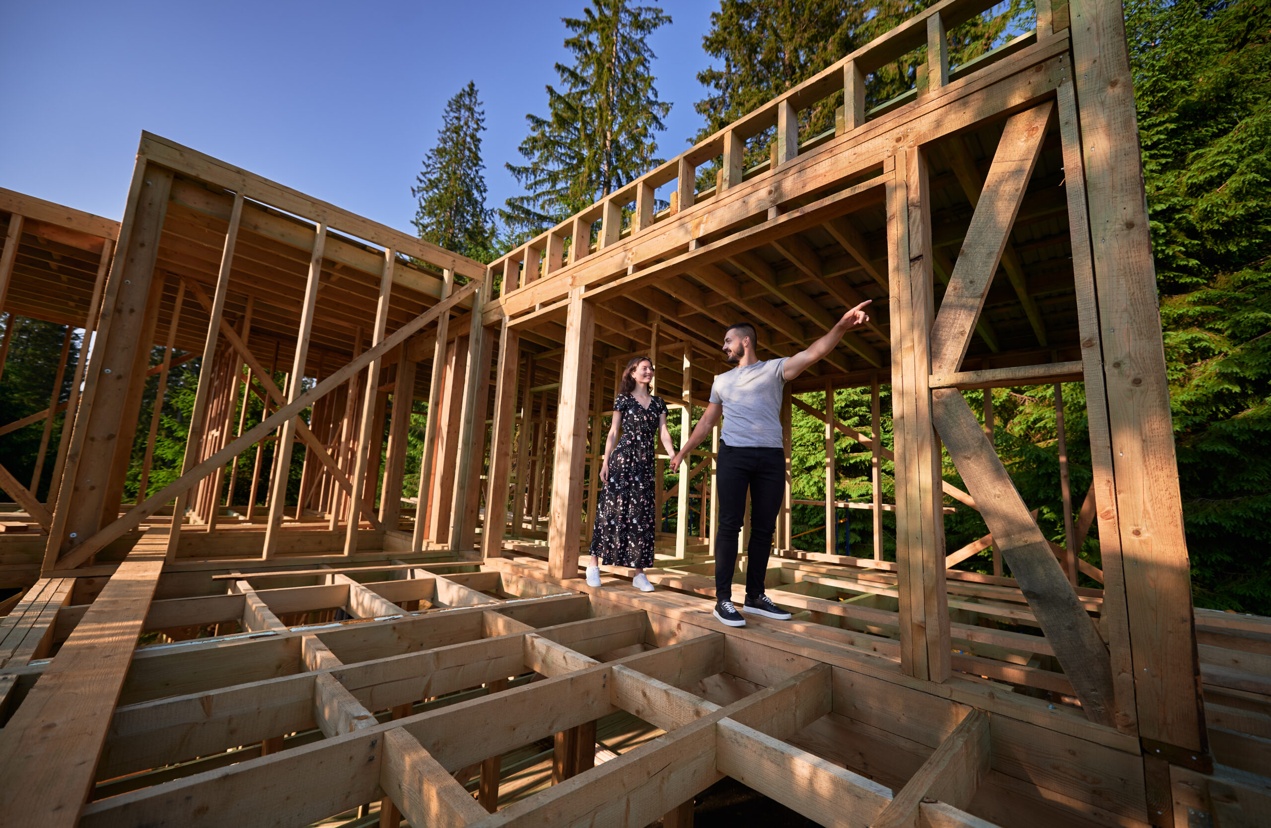 Couple viewing framed structure of custom home by Capstone Custom Homes